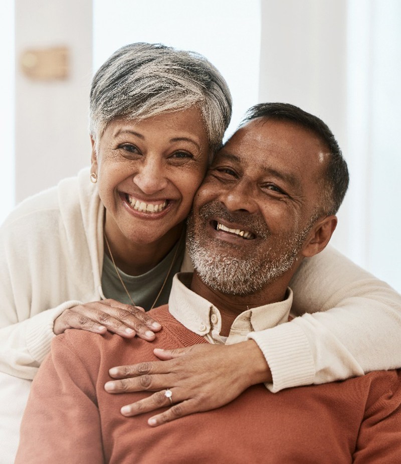 An older couple shows off their healthy smiles