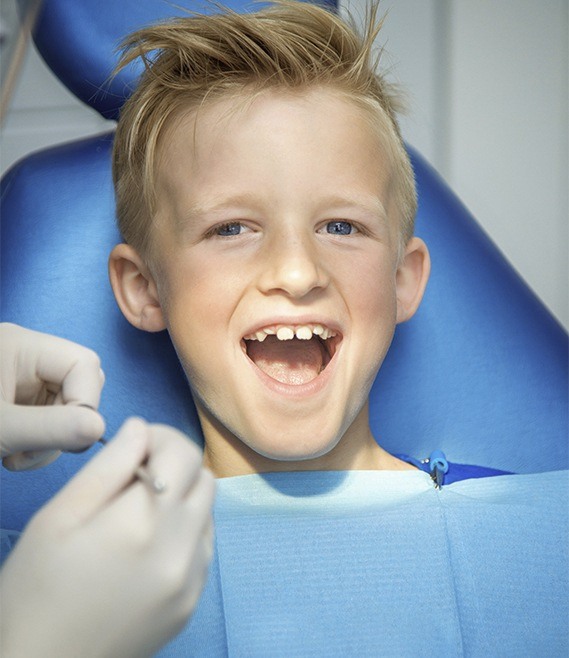 Child laughing in dental chair after silver diamine fluoride treatment