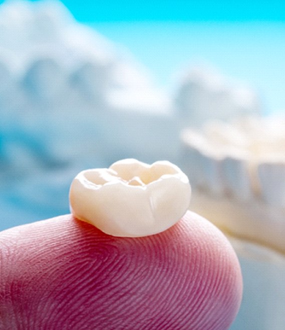 Patient holding up dental crown