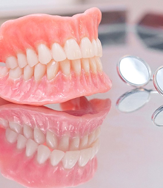 A full set of dentures designed for a person with missing teeth and dental instruments sitting on a table in Panama City