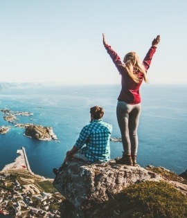 Two people on a cliff overlooking the ocean