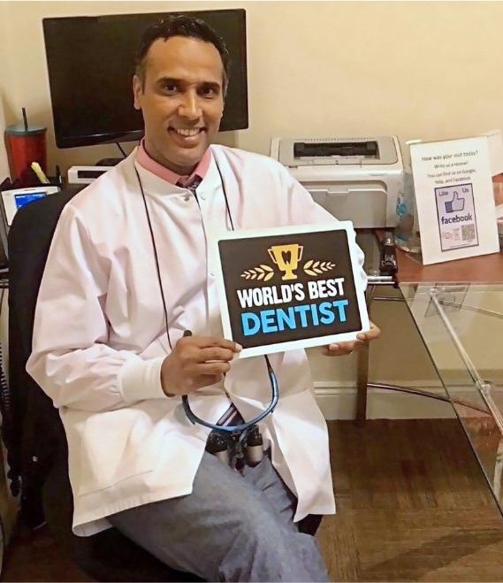 Doctor Waheed holding a best dentist sign