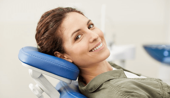 a patient smiling about the cost of tooth extractions