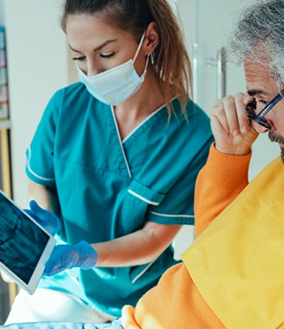 Dentist showing patient X-ray of dental implants in Panama City