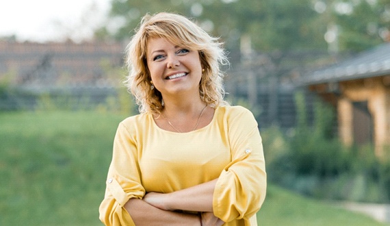 Woman in yellow shirt smiling outside