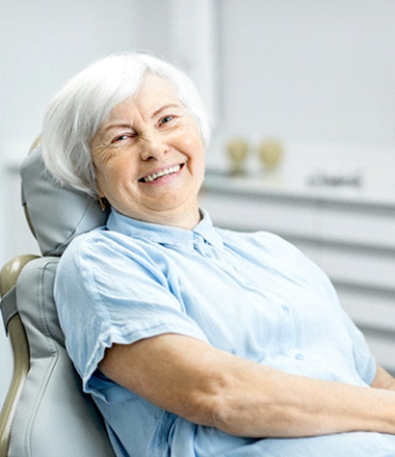 Senior woman smiling after implant denture treatment