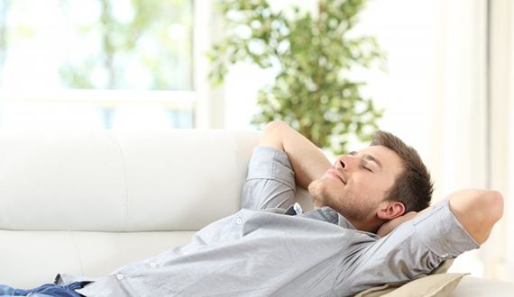 a man resting on his couch at home