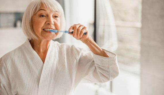 a woman brushing her teeth after a shower
