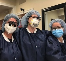 Three dental team members wearing protective gear