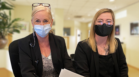 Two dental team members behind the reception desk