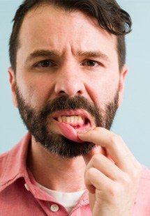 man pointing to inflamed gums 