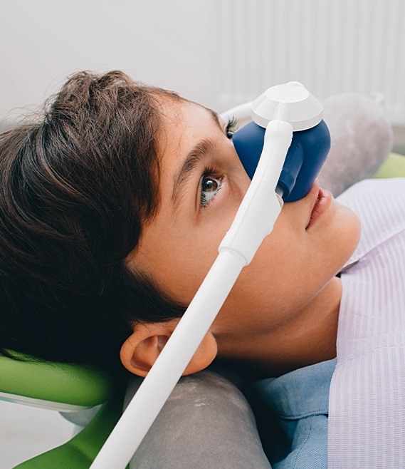Young patient receiving treatment with nitrous oxide dental sedation mask