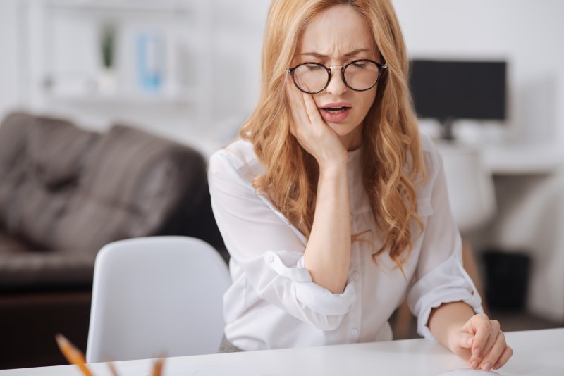 Woman with toothache from teeth whitening with cavities