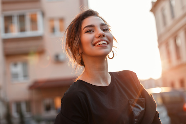 young woman smiling at sunset