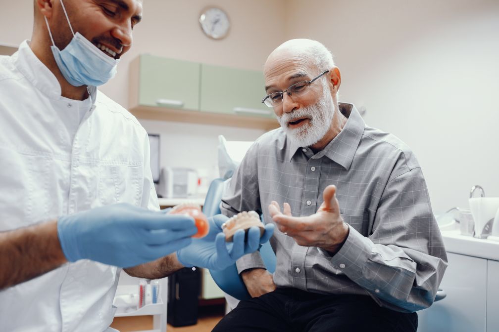 A man discussing dentures with his dentist.